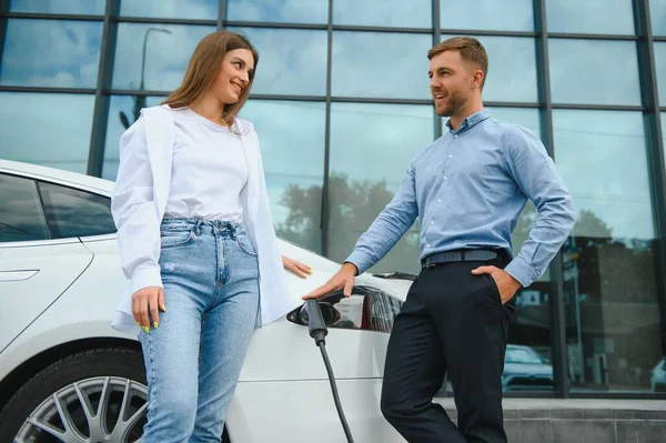 Happy Young Adult Man Smiling Woman Charging Electric Car — Stock Fotó