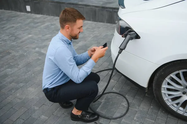 Man Charging His Electric Car Charge Station Using Smartphone — Stock Photo, Image