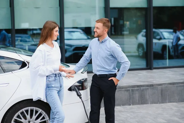 Happy Young Adult Man Smiling Woman Charging Electric Car — Stock Fotó