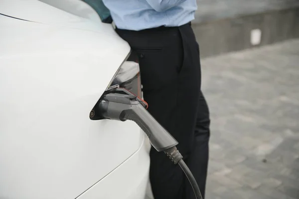 Een Zakenman Rekent Een Elektrische Auto — Stockfoto