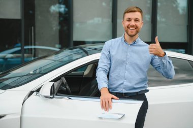 Always available. Handsome young businessman near his car outdoors.