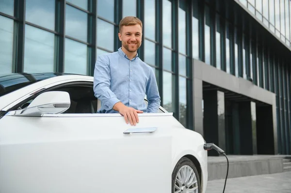 Lässiger Mann Mit Smartphone Der Nähe Von Elektroauto Wartet Auf — Stockfoto