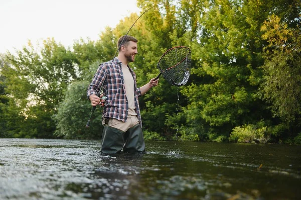 Pescatore Raccogliendo Grande Trota Arcobaleno Dalla Sua Rete Pesca — Foto Stock