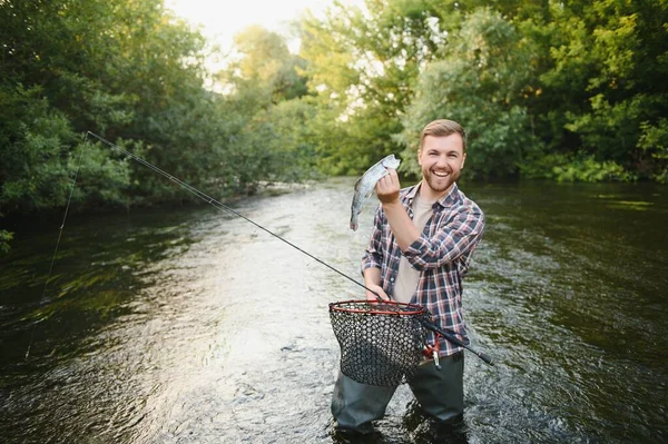 渔夫在河里钓到了一条鳟鱼 — 图库照片