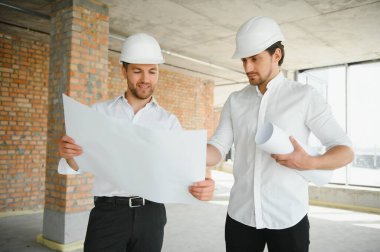 Two young man architect on a building construction site.