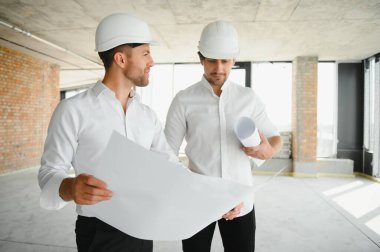 Two young man architect on a building construction site.