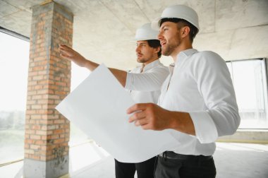 Two young man architect on a building construction site.