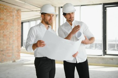 Two Specialists Inspect Commercial, Industrial Building Construction Site. Real Estate Project with Civil Engineer.