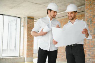 Two Specialists Inspect Commercial, Industrial Building Construction Site. Real Estate Project with Civil Engineer.