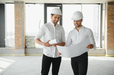 Two young man architect on a building construction site.
