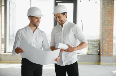 Male Architect Giving Instructions To His Foreman At Construction Site