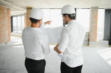 Two Specialists Inspect Commercial, Industrial Building Construction Site. Real Estate Project with Civil Engineer.