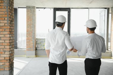 Two young man architect on a building construction site.
