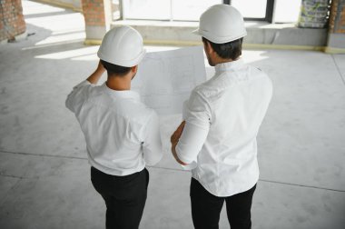 Male Architect Giving Instructions To His Foreman At Construction Site