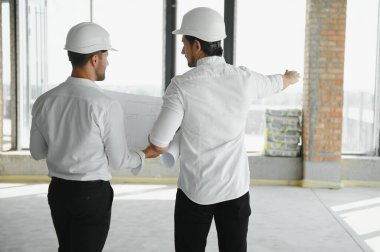 Two young man architect on a building construction site.