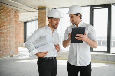 Male Architect Giving Instructions To His Foreman At Construction Site