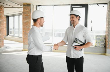 Two young man architect on a building construction site.