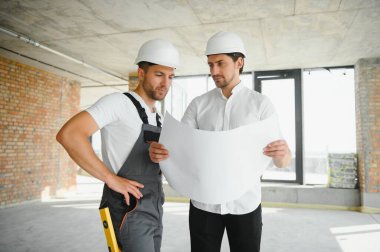 İnşaat mühendisi ve mimar inşaat alanında mavi baskı ile çalışma kavramı