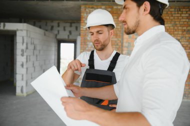 bir işçi ve bir inşaat hakkında bazı bilgileri izlerken mimar görünümü.