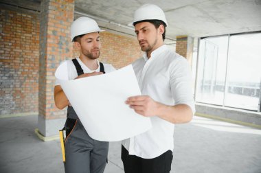 bir işçi ve bir inşaat hakkında bazı bilgileri izlerken mimar görünümü.