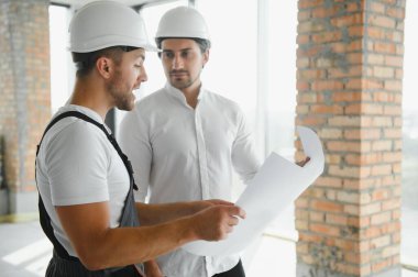 bir işçi ve bir inşaat hakkında bazı bilgileri izlerken mimar görünümü.