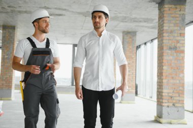 Male Architect Giving Instructions To His Foreman At Construction Site