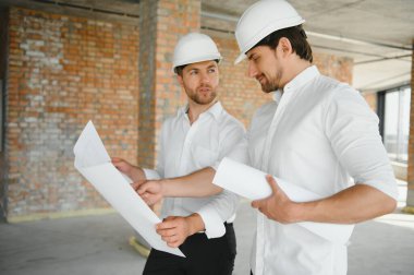Two young man architect on a building construction site.