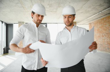 Two Specialists Inspect Commercial, Industrial Building Construction Site. Real Estate Project with Civil Engineer.