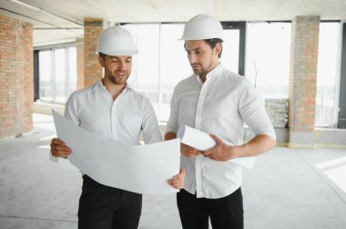 Two Specialists Inspect Commercial, Industrial Building Construction Site. Real Estate Project with Civil Engineer.