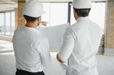 Two young man architect on a building construction site.