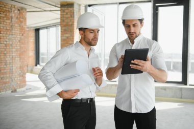 Two Specialists Inspect Commercial, Industrial Building Construction Site. Real Estate Project with Civil Engineer.