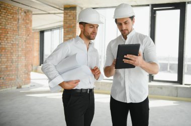 Two young man architect on a building construction site.
