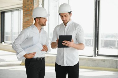 Two Specialists Inspect Commercial, Industrial Building Construction Site. Real Estate Project with Civil Engineer.