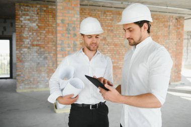 Two Specialists Inspect Commercial, Industrial Building Construction Site. Real Estate Project with Civil Engineer.