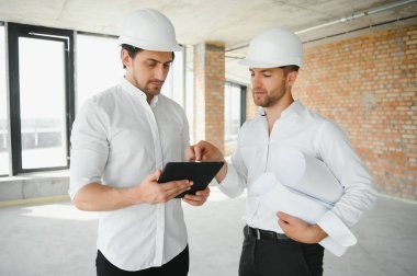 Two young man architect on a building construction site.