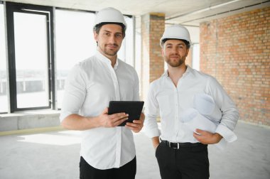 Two Specialists Inspect Commercial, Industrial Building Construction Site. Real Estate Project with Civil Engineer.