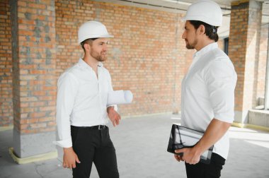 Two young man architect on a building construction site.