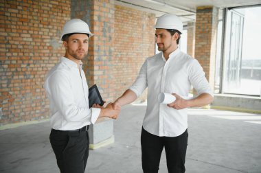 Two Specialists Inspect Commercial, Industrial Building Construction Site. Real Estate Project with Civil Engineer.