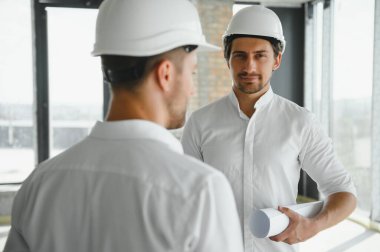 Two Specialists Inspect Commercial, Industrial Building Construction Site. Real Estate Project with Civil Engineer.