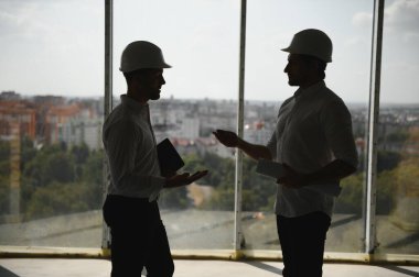 Male Architect Giving Instructions To His Foreman At Construction Site