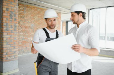 bir işçi ve bir inşaat hakkında bazı bilgileri izlerken mimar görünümü.