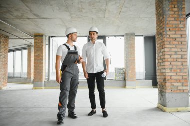 İnşaat mühendisi ve mimar inşaat alanında mavi baskı ile çalışma kavramı