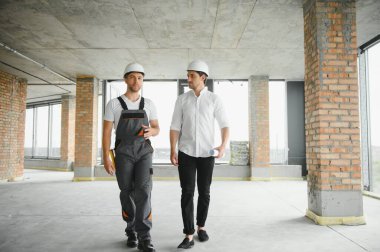 İnşaat mühendisi ve mimar inşaat alanında mavi baskı ile çalışma kavramı