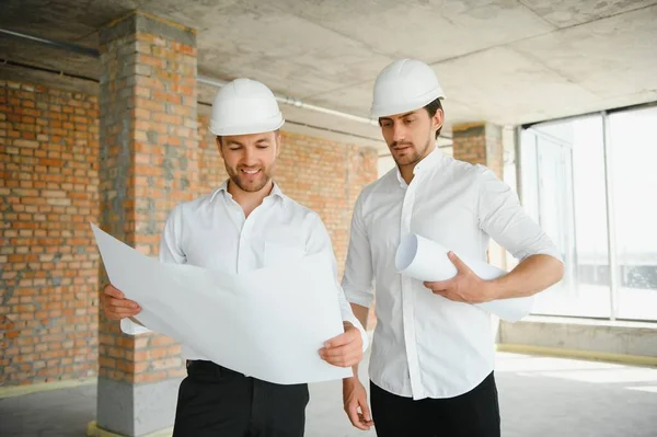 Two young man architect on a building construction site.
