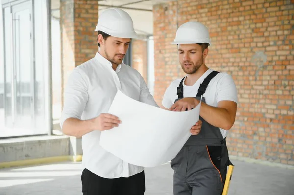 Construction concept of Engineer and Architect working at Construction Site with blue print