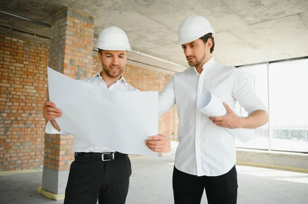 Two Specialists Inspect Commercial, Industrial Building Construction Site. Real Estate Project with Civil Engineer.
