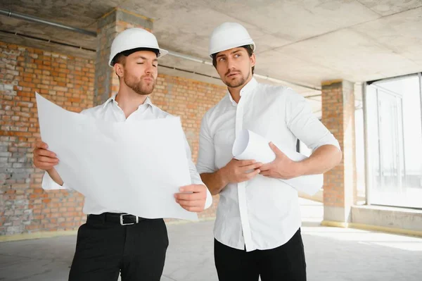 Two young man architect on a building construction site.