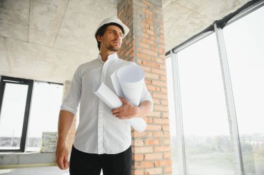 İnşaat alanında çalışan mühendislerin elinde planlar var. Mühendislik ve mimarlık konsepti..