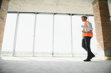 İnşaat alanında çalışan mühendislerin elinde planlar var. Mühendislik ve mimarlık konsepti..