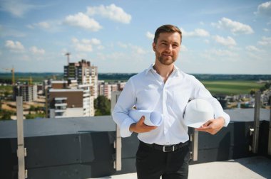 İnşaat alanında çalışan mühendislerin elinde planlar var. Mühendislik ve mimarlık konsepti..